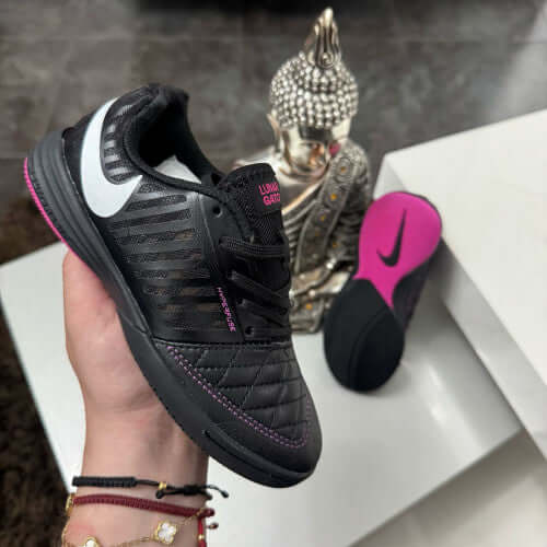 NIKE Lunar Gato Futsal Dama shoe showcased with a Buddha statue in the background, highlighting its sleek design and vibrant sole.