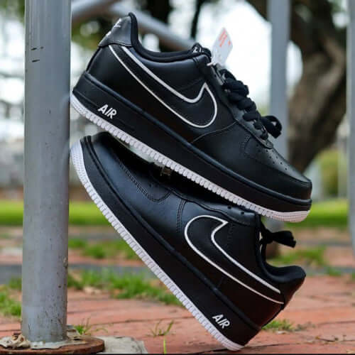 NIKE FORCE ONE HOMBRE black sneakers hanging on a pole, showcasing their stylish design and AIR branding.