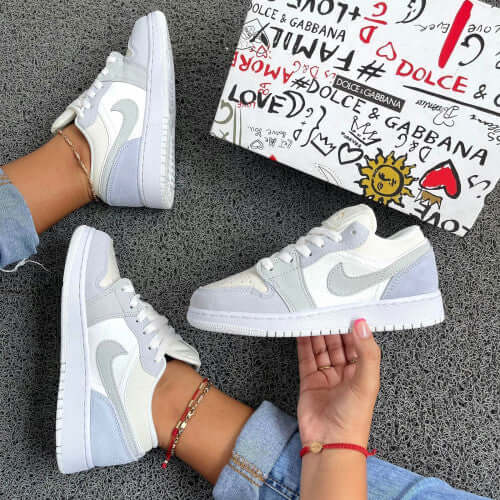 Stylish NIKE sneakers in gray and white, paired with a Dolce & Gabbana box, showcasing trendy urban fashion.