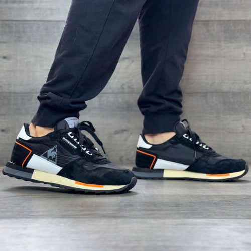 Stylish LE COQ SPORTIF HOMBRE sneakers in black and orange, perfect for fashion-forward looks and everyday comfort.