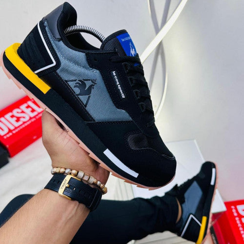 Stylish LE COQ SPORTIF HOMBRE sneakers in black and grey, perfect for casual wear and sporty looks.