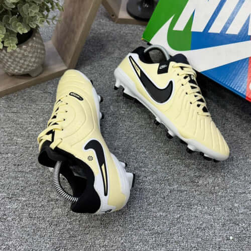 Nike Tiempo Guayo Dama soccer cleats in yellow and black, designed for women's performance on the field.